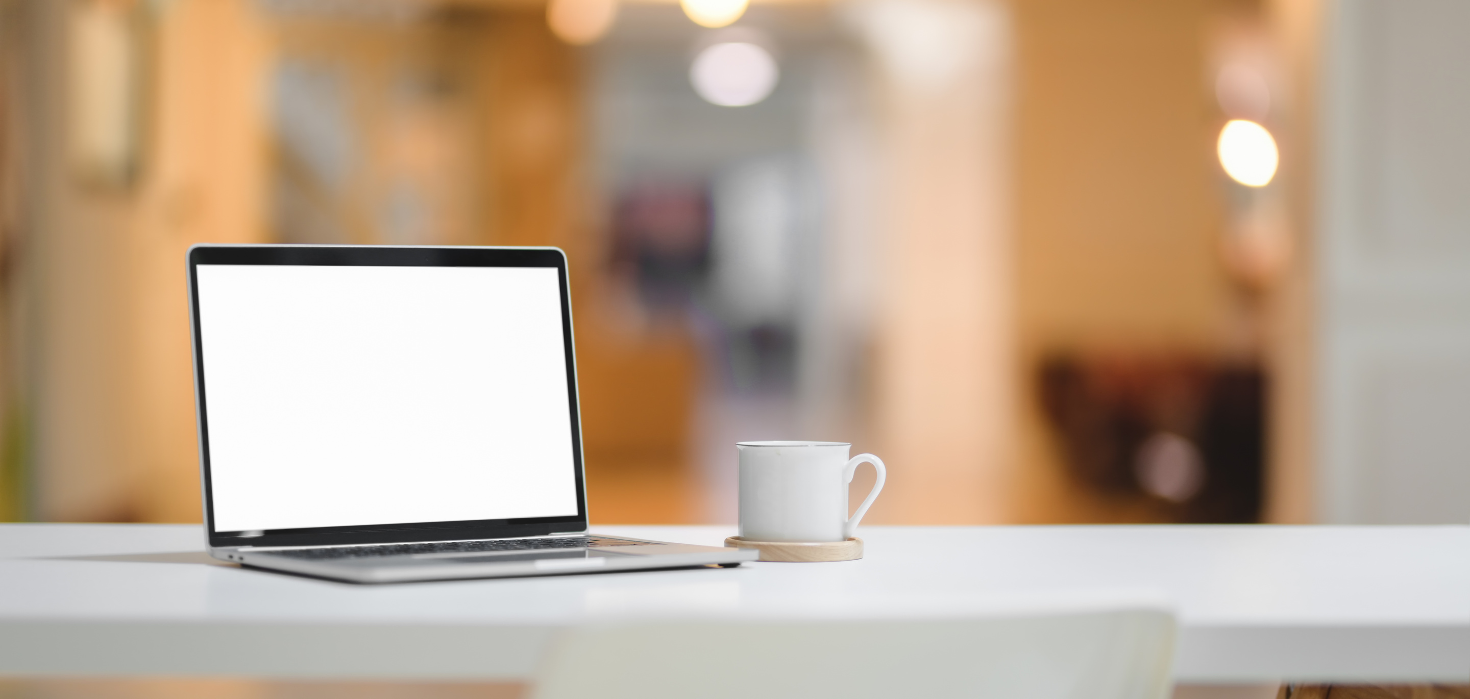 White Ceramic Mug and Laptop Computer on Table