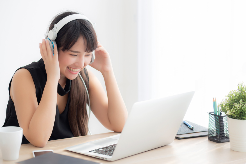 Happy Woman with Headphones and Laptop